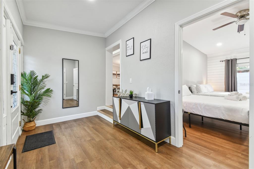 An entryway with wood-look flooring, a modern sideboard, and a doorway leading to a bedroom — 414 JOYCE AVENUE, TEMPLE TERRACE, FL
