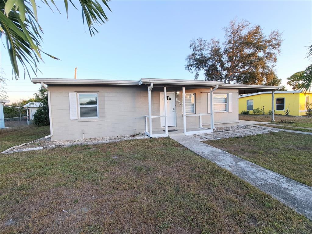 A single-story gray house with a white front door and a concrete walkway — 3934 CONWAY BOULEVARD, PORT CHARLOTTE, FL