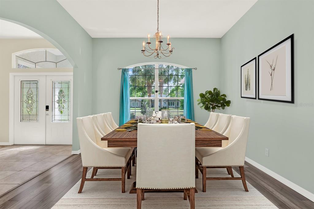 A dining room features a long wooden table, cream upholstered chairs, and light green walls — 1155 E BLUEBIRD COURT, HERNANDO, FL