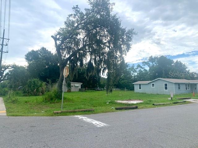 A large tree stands on a grassy lot next to a light blue mobile home — 2904 PARK STREET, EATON PARK, FL