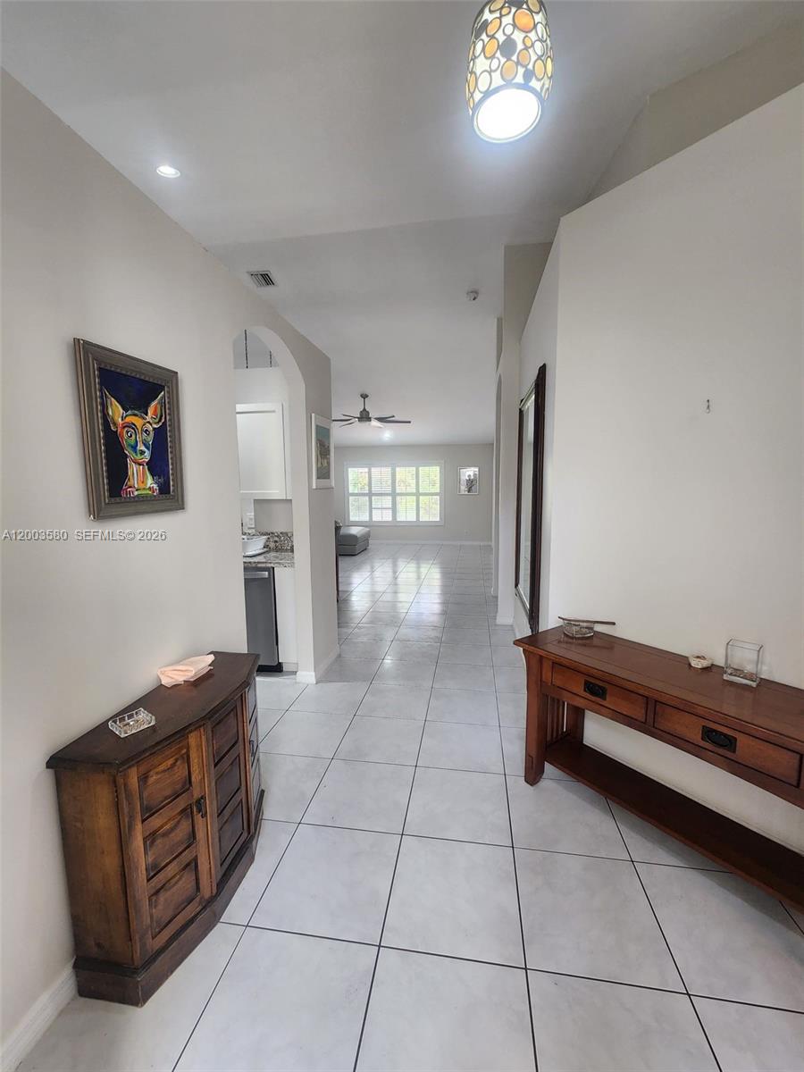 A tiled entryway leads to a living area with a kitchen visible on the left — 6053 Heliconia Rd, Delray Beach FL 33484, DELRAY BEACH, FL