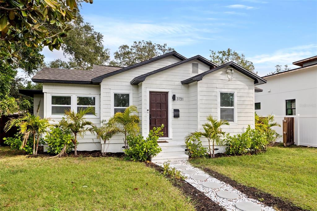 A one-story house with white siding, a dark brown front door, and a stone walkway — 3731 6TH AVENUE N, ST PETERSBURG, FL