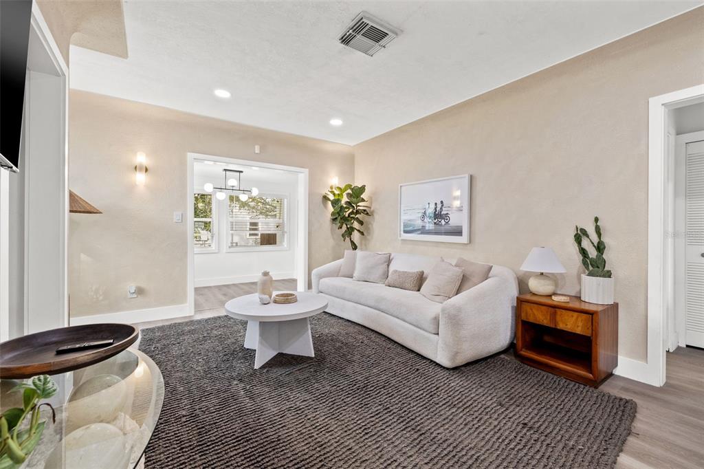 A living room features a white sofa, a round coffee table, and a dark rug — 3731 6TH AVENUE N, ST PETERSBURG, FL