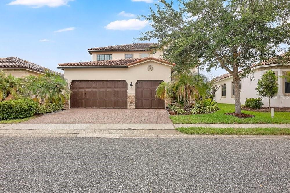 A two-story house with a three-car garage and a paved driveway — 10459 STAPELEY DRIVE, ORLANDO, FL