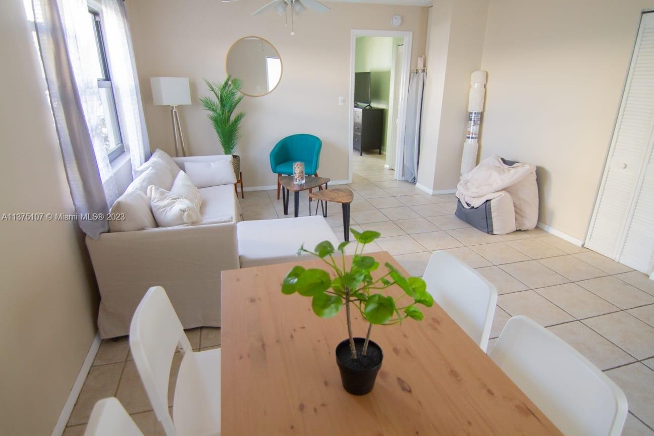 A living room and dining area feature light tile floors, a sofa, and a table — 753 Michigan Ave # 2D, Miami Beach FL 33139, MIAMI BEACH, FL