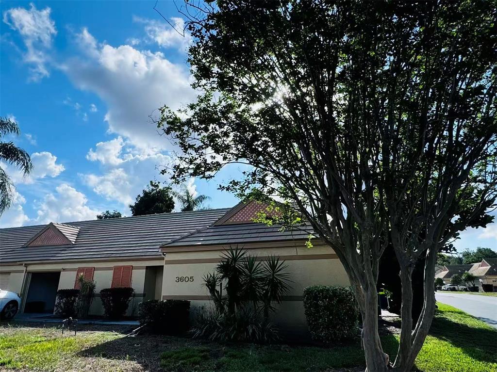 A single-story residential building with a tiled roof and a large tree in front — 3605 57TH  AVENUE DR W, BRADENTON, FL
