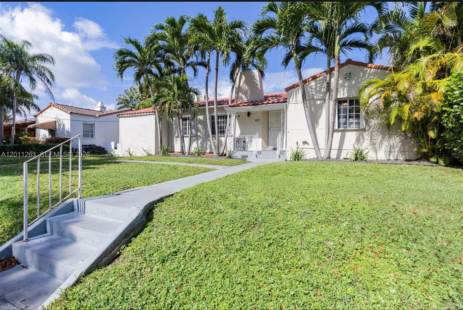 A single-story house with a tiled roof, palm trees, and a concrete walkway — 437 NE 107th St, Miami FL 33161, MIAMI, FL