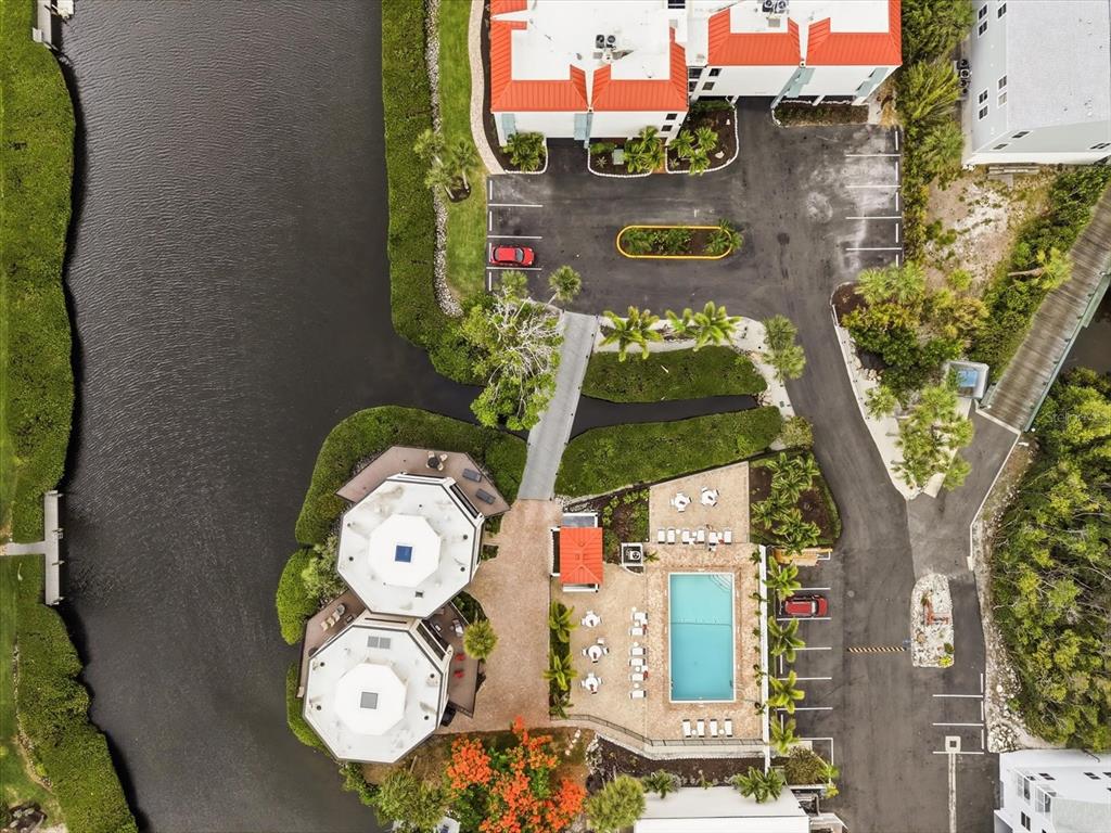 An aerial view shows a swimming pool, two octagonal buildings, and a parking lot — 3705 E BAY DRIVE UNIT 117, HOLMES BEACH, FL