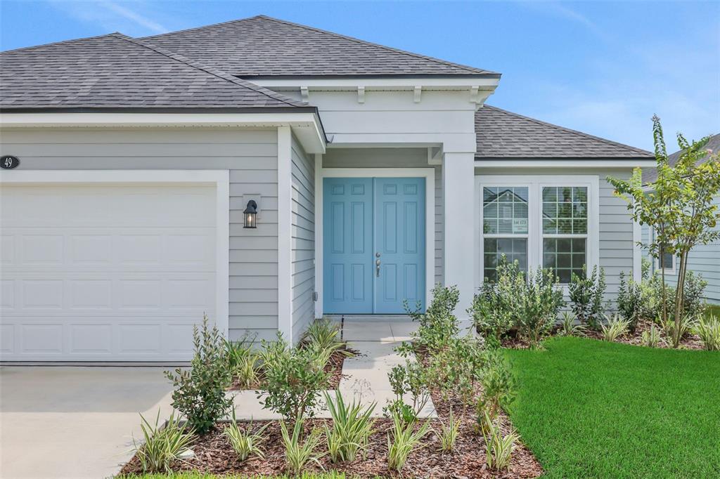 A light gray house exterior features a blue double front door and a white garage — 49 WINDMILL PALM WAY, PALM COAST, FL