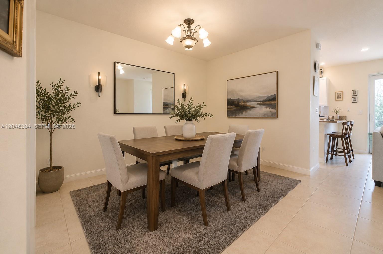 A dining room features a wooden table with six upholstered chairs on a gray rug — 10934 W 33rd Way, Hialeah FL 33018, HIALEAH, FL