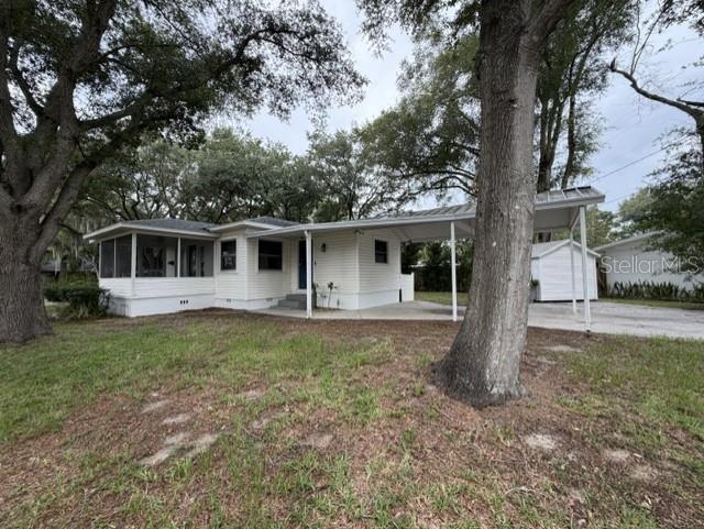 A white single-story house features a screened-in front porch and an attached carport — 540 FRANCIS BOULEVARD, LAKELAND, FL