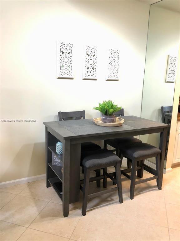 A dining area features a dark gray wooden table with built-in shelving and four stools — 4812 S Central Blvd # 25, Jupiter FL 33458, JUPITER, FL