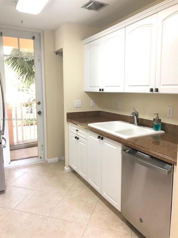 A kitchen features white cabinets, brown countertops, a stainless steel dishwasher, and a glass door — 4812 S Central Blvd # 25, Jupiter FL 33458, JUPITER, FL