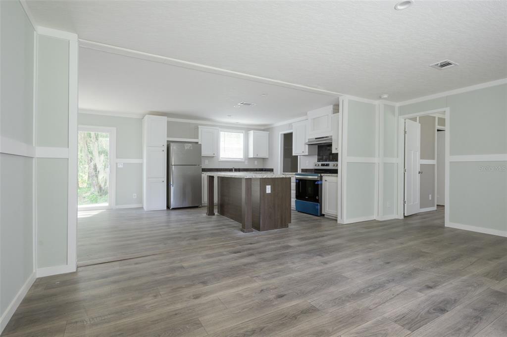 A kitchen with a center island, stainless steel appliances, and light gray wood-look flooring — 374 SISCO ROAD, POMONA PARK, FL