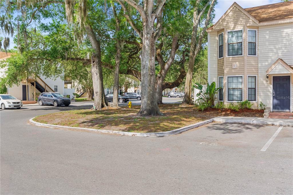 A two-story residential building exterior with a parking lot and large trees in front — 2302 MAKI ROAD UNIT 66, PLANT CITY, FL