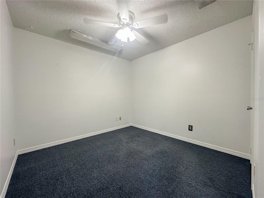 An empty bedroom with white walls, dark blue carpet, and a ceiling fan — 336 E PLANT STREET, WINTER GARDEN, FL