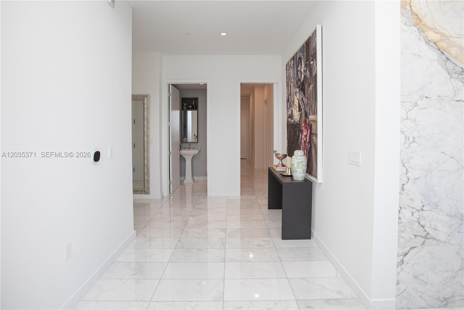 A bright hallway features white marble flooring, a console table, and two doorways — 2821 S Bayshore Dr # 20D, Miami FL 33133, MIAMI, FL