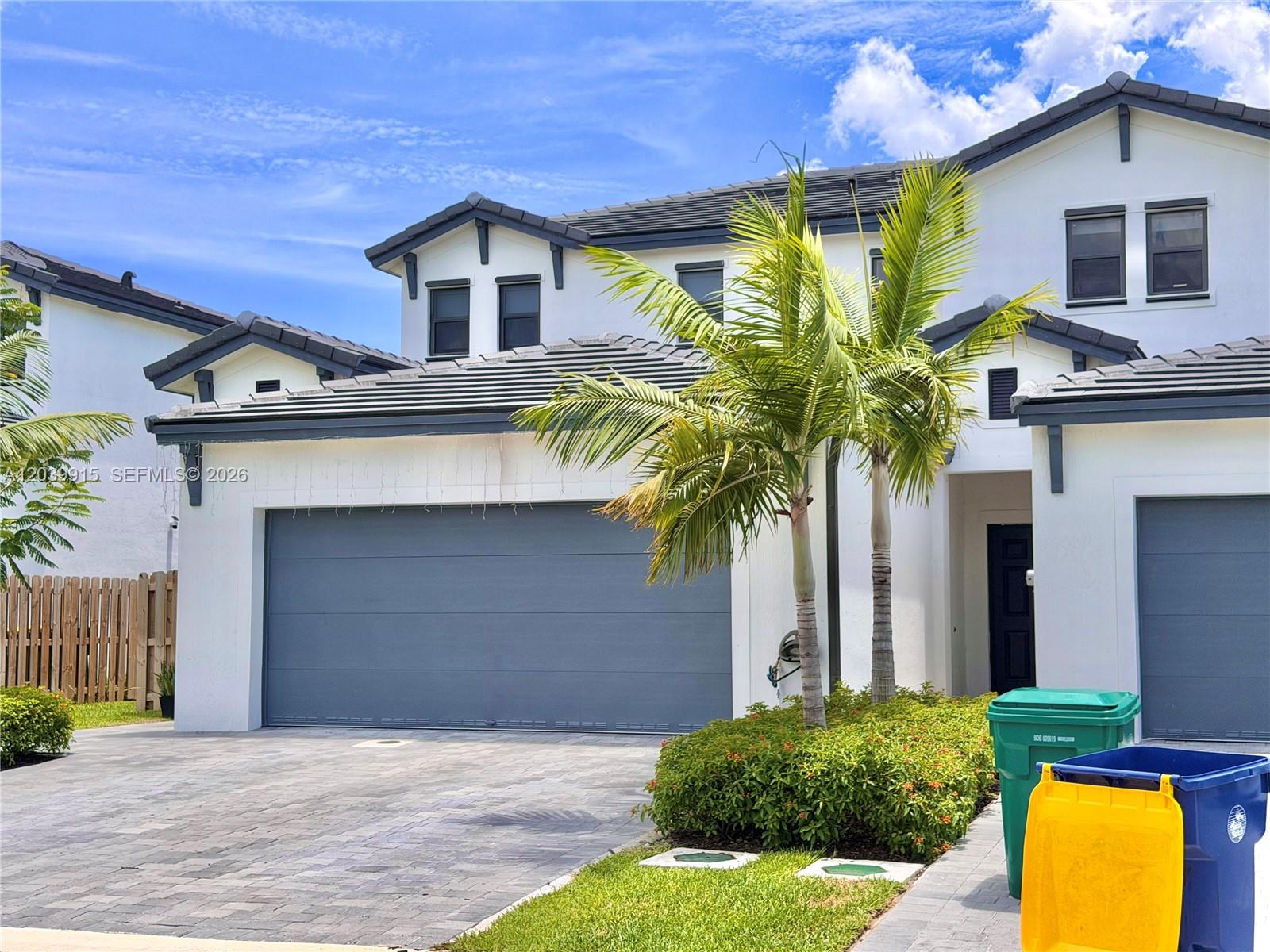 A two-story house exterior features a gray garage door, white stucco walls, and palm trees — 2950 Park Pl # 5838, Dania Beach FL 33312, DANIA BEACH, FL