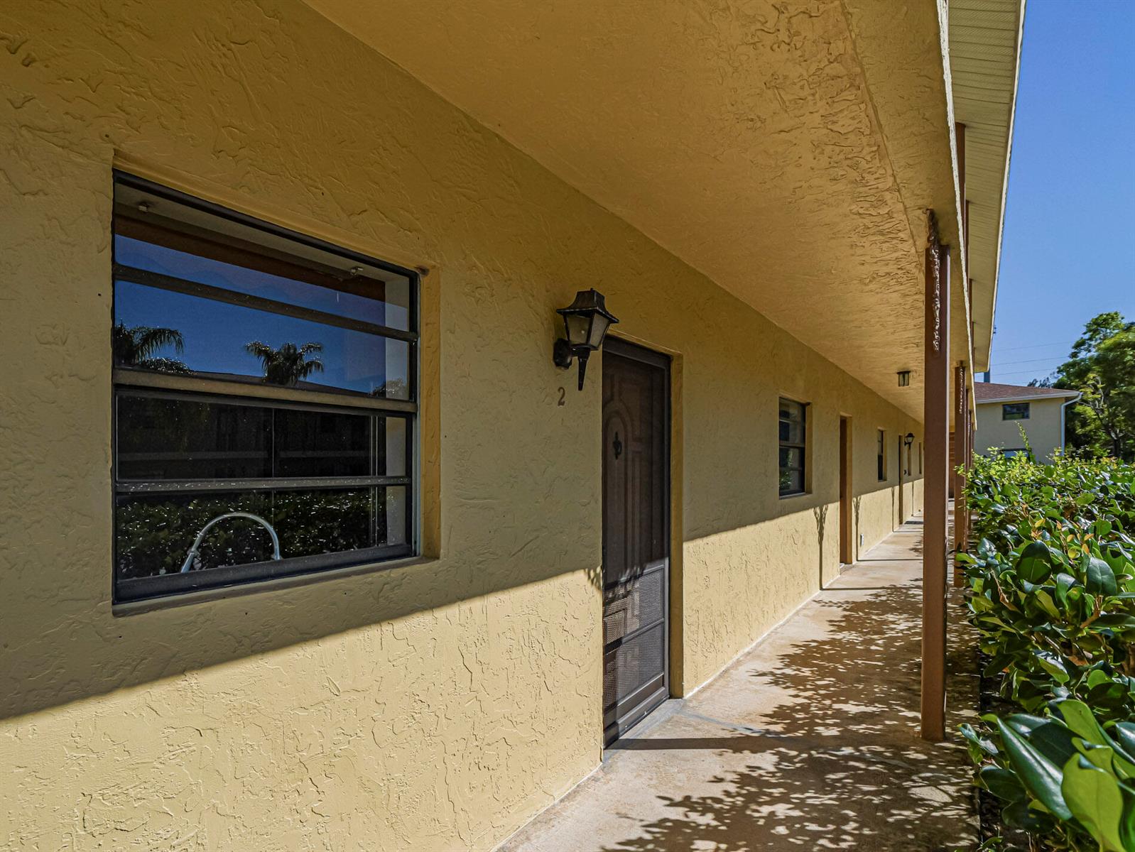 An exterior walkway leads past a series of apartment doors and windows on a building — 400 18th Street # G2, Vero Beach FL 32960, VERO BEACH, FL