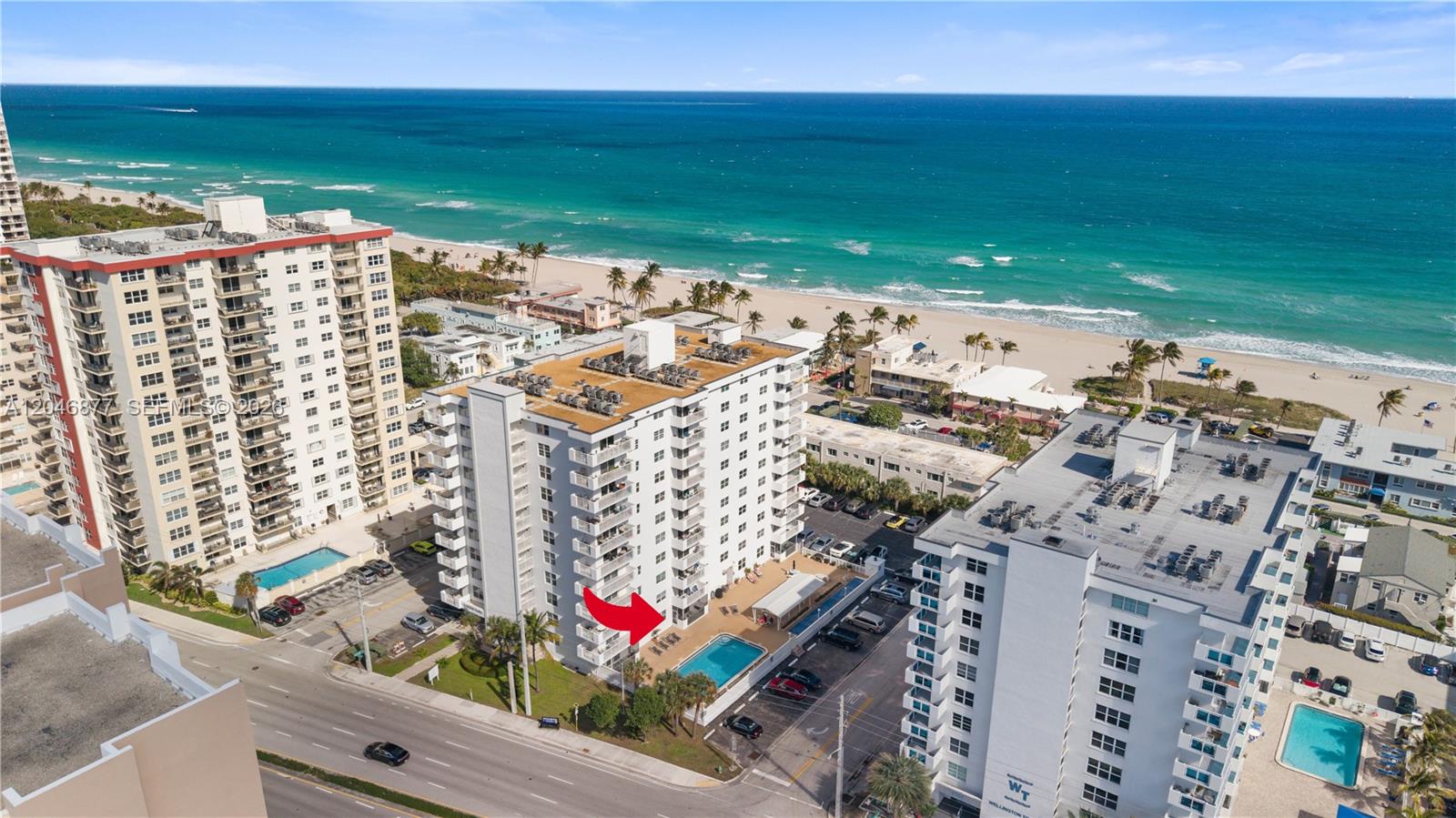 An aerial view shows several high-rise apartment buildings located along a sandy beach — 1601 S Ocean Dr # 105, Hollywood FL 33019, HOLLYWOOD, FL