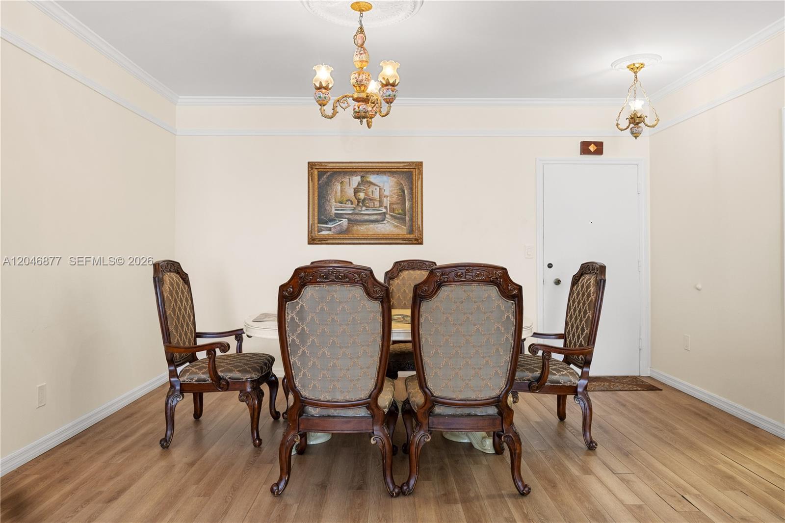 A dining room features a wooden table with six upholstered chairs under two chandeliers — 1601 S Ocean Dr # 105, Hollywood FL 33019, HOLLYWOOD, FL