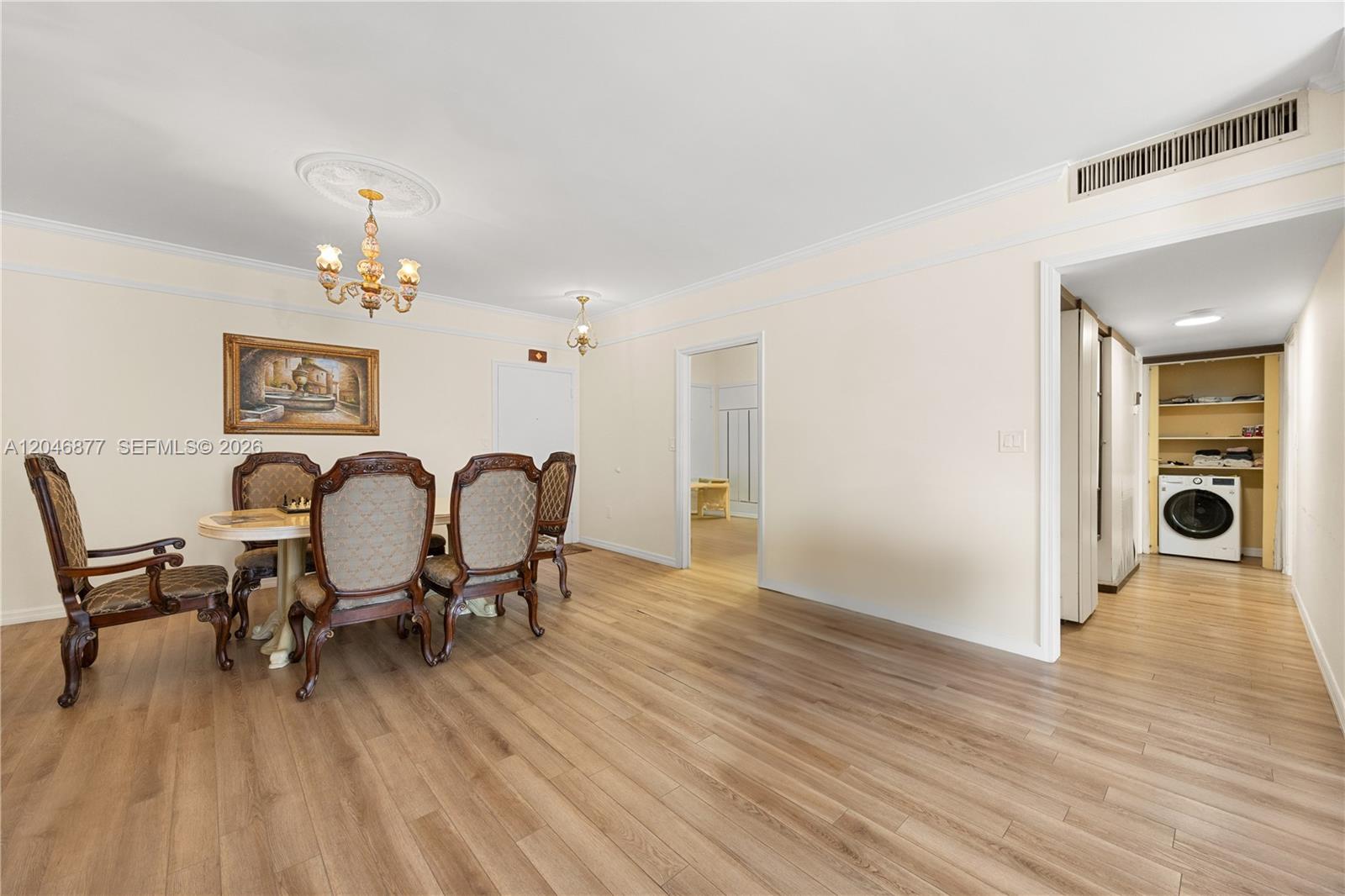 A dining room with wood-look flooring, a chandelier, and an adjacent laundry area — 1601 S Ocean Dr # 105, Hollywood FL 33019, HOLLYWOOD, FL