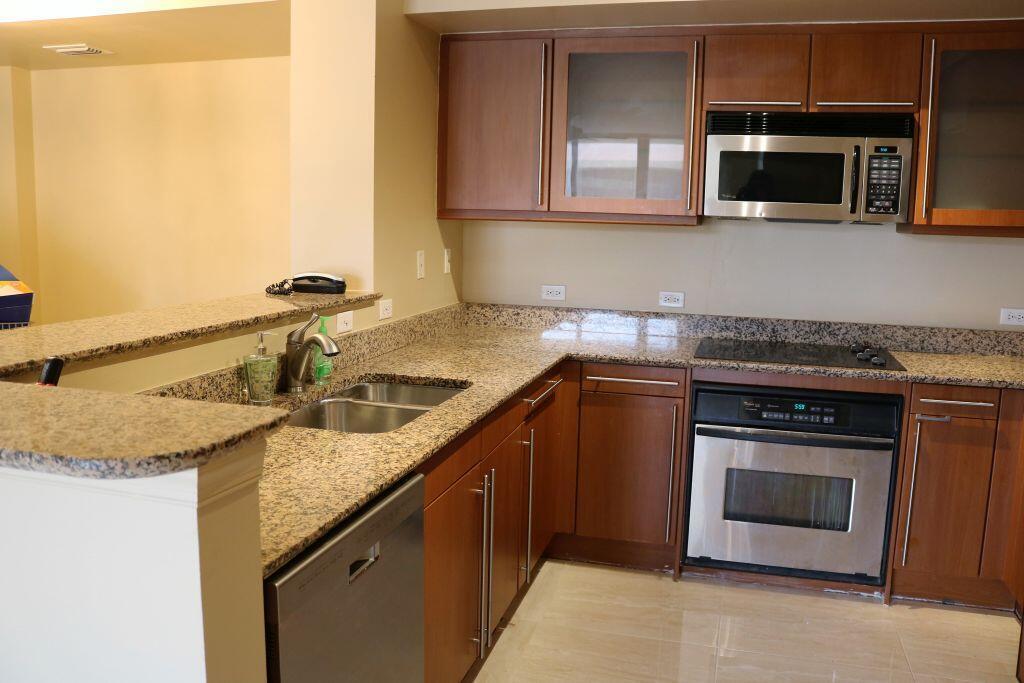 A kitchen with granite countertops, stainless steel appliances, and wood cabinetry — 2080 S Ocean Drive # 703, Hallandale Beach FL 33009, HALLANDALE BEACH, FL