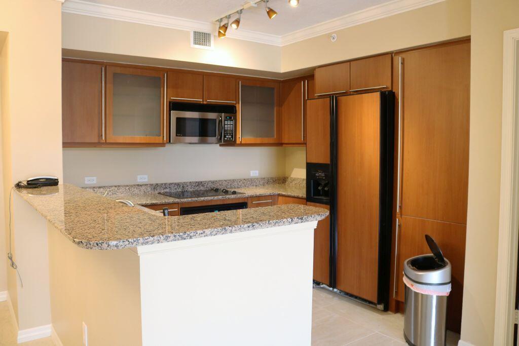 A kitchen with wood cabinets, granite countertops, stainless steel appliances, and a breakfast bar — 2080 S Ocean Drive # 703, Hallandale Beach FL 33009, HALLANDALE BEACH, FL