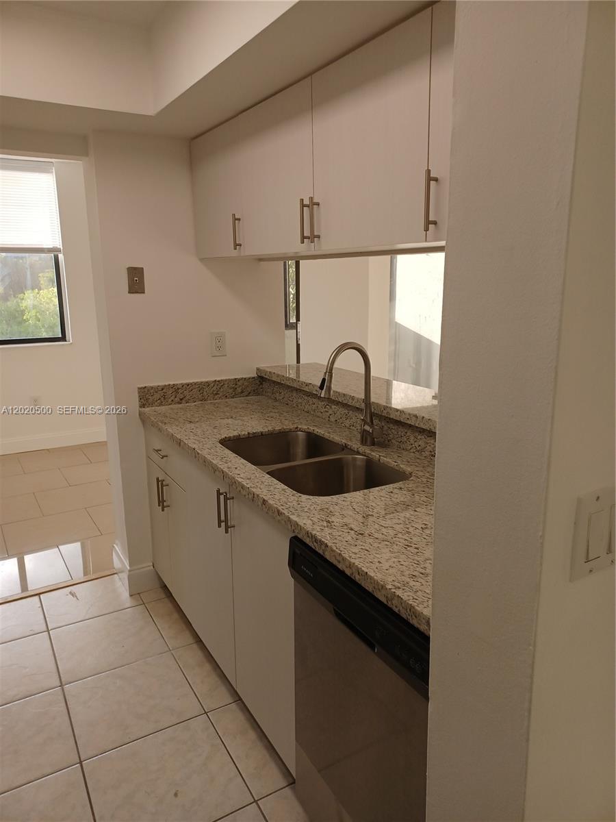 A kitchen features white cabinets, granite countertops, a double sink, and a dishwasher — 8275 SW 152nd Ave # 416, Miami FL 33193, MIAMI, FL