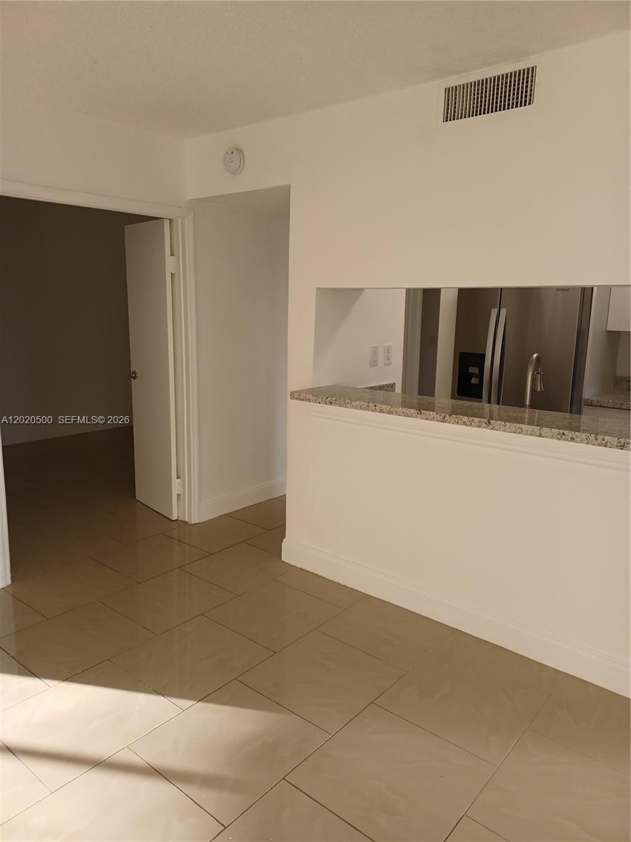 A tiled room features a granite-topped pass-through window looking into a kitchen with stainless appliances — 8275 SW 152nd Ave # 416, Miami FL 33193, MIAMI, FL