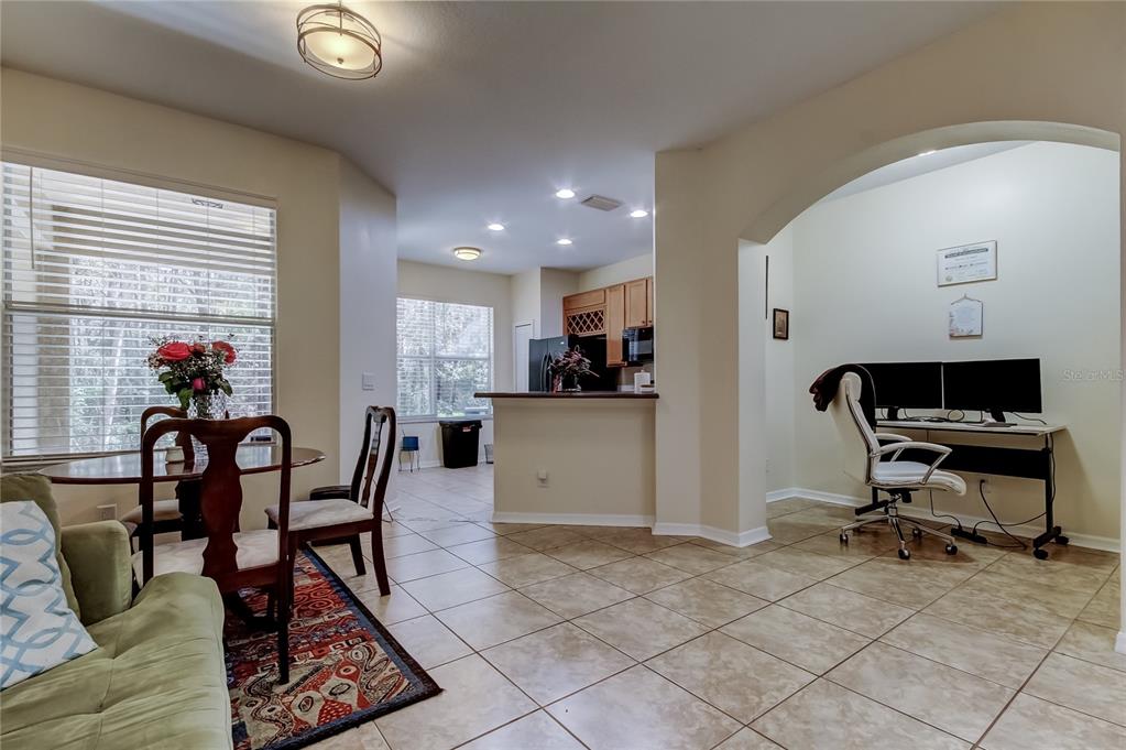 A dining area with a rug and table sits beside an open kitchen and office — 12660 SILVERDALE STREET, TAMPA, FL