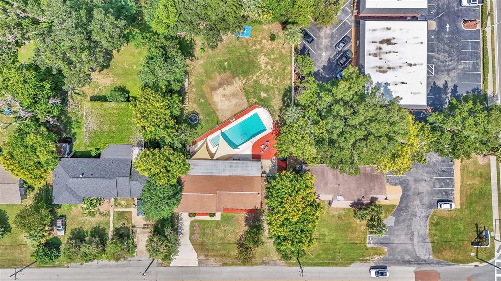 An aerial view shows a residential property with a swimming pool, patio, and surrounding trees — 2433 NE 2ND STREET, OCALA, FL