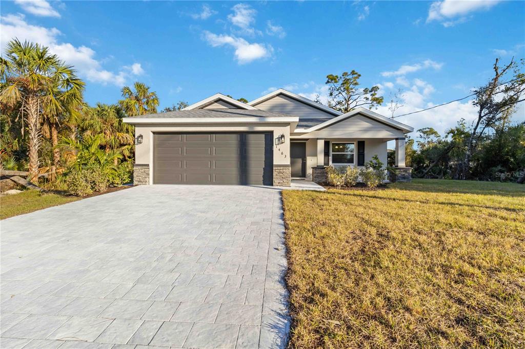 A single-story suburban house with a gray garage, paved driveway, and a covered front porch — 6316 DEER RUN RD, NORTH PORT, FL