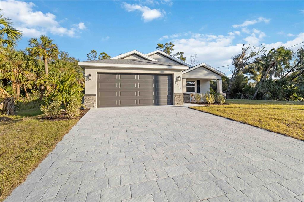 A single-story house with a gray garage door and a paved driveway — 6316 DEER RUN RD, NORTH PORT, FL