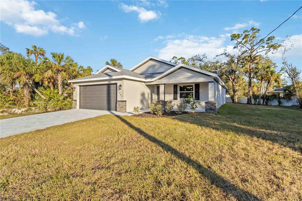 A single-story house with a gray garage, light-colored stucco exterior, and a paved driveway — 6316 DEER RUN RD, NORTH PORT, FL