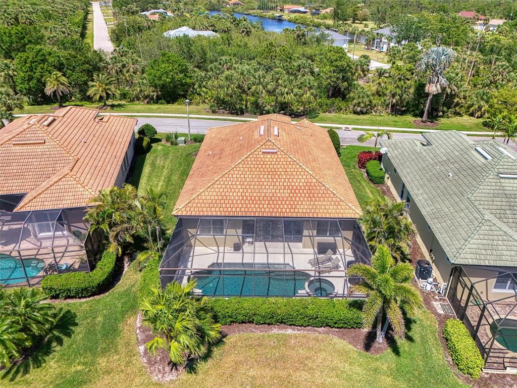 An aerial view of a house with a tiled roof, screened pool, and backyard landscaping — 13217 SCRUB JAY COURT, PORT CHARLOTTE, FL