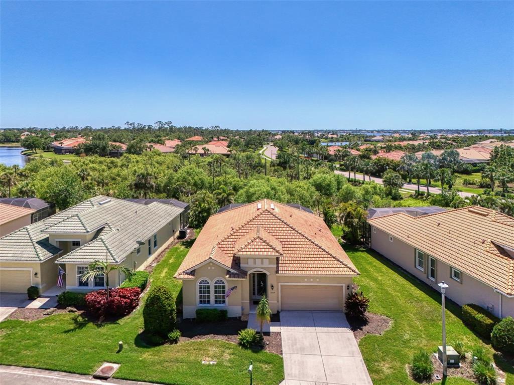 An aerial view shows a single-story house with a tile roof and a concrete driveway — 13217 SCRUB JAY COURT, PORT CHARLOTTE, FL