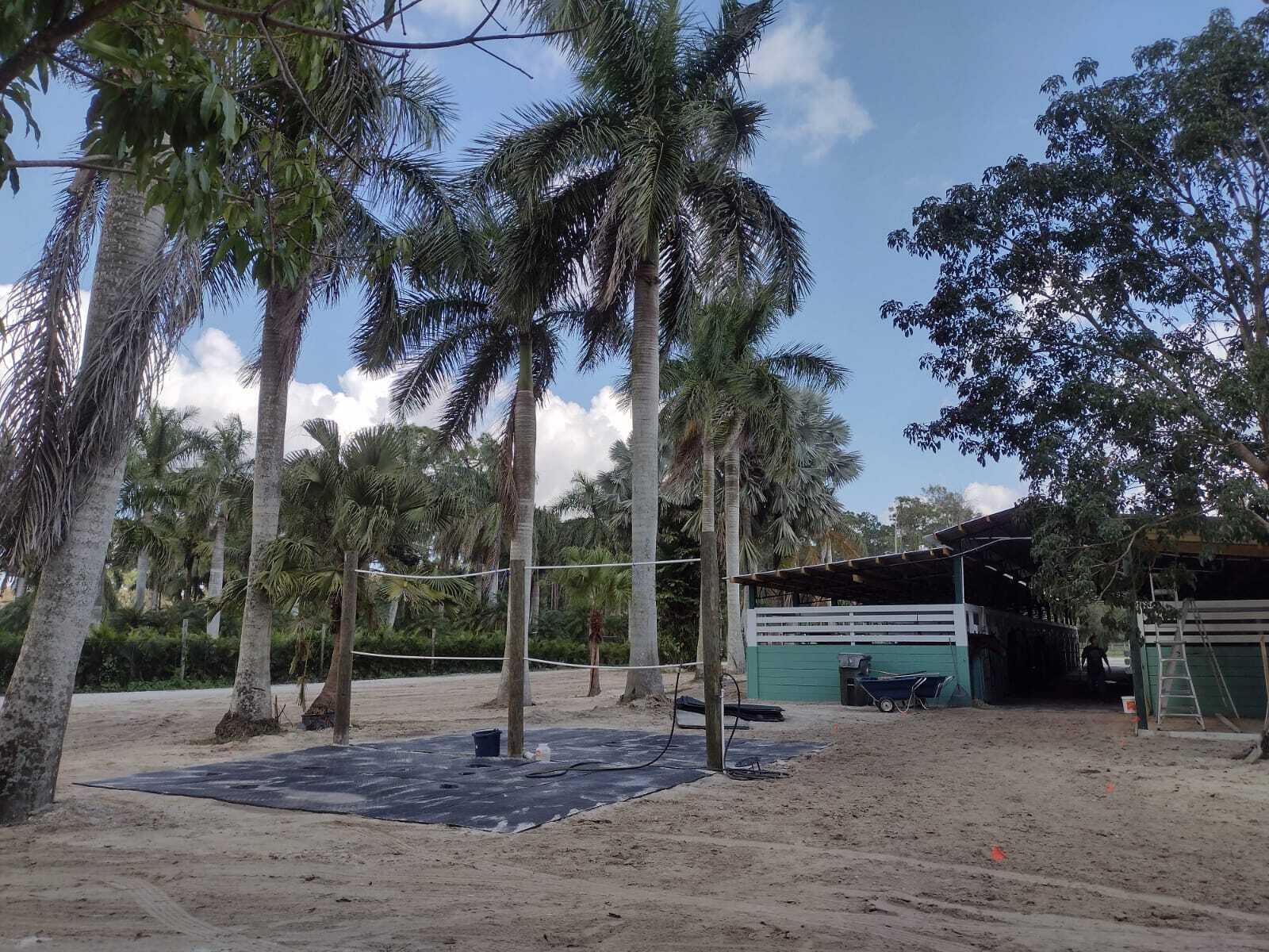 An outdoor area features a black mat, wooden posts, and a nearby stable building — 1100 D Road, FL 33470, FL