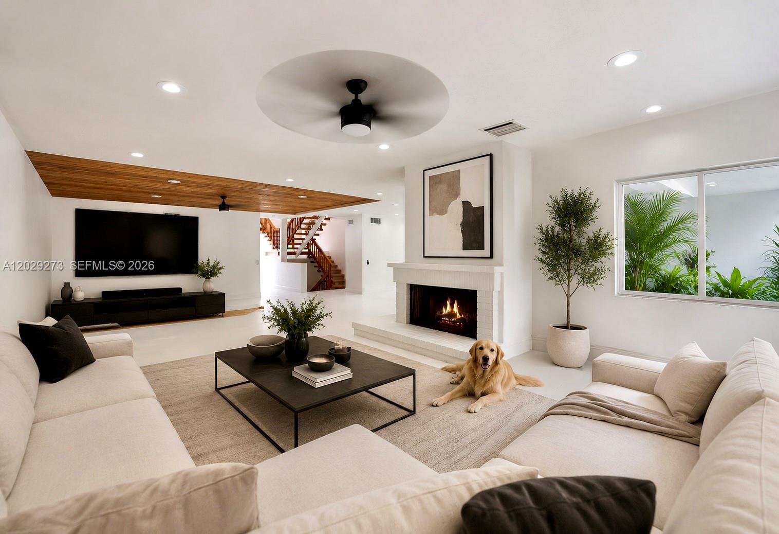 A living room features a white fireplace, a wooden ceiling accent, and a golden retriever — 2000 S Bayshore Dr # 58, Miami FL 33133, MIAMI, FL