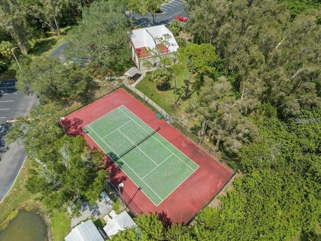 An aerial view shows a tennis court next to a small building and wooded area — 9100 DR MARTIN LUTHER KING JR STREET N UNIT 1707, ST PETERSBURG, FL