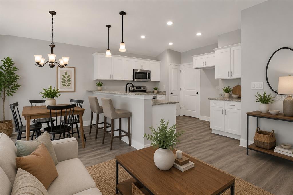 A kitchen and dining area with white cabinets, granite countertops, and wood-look flooring — 4368 MERCEDES STREET, SEBRING, FL