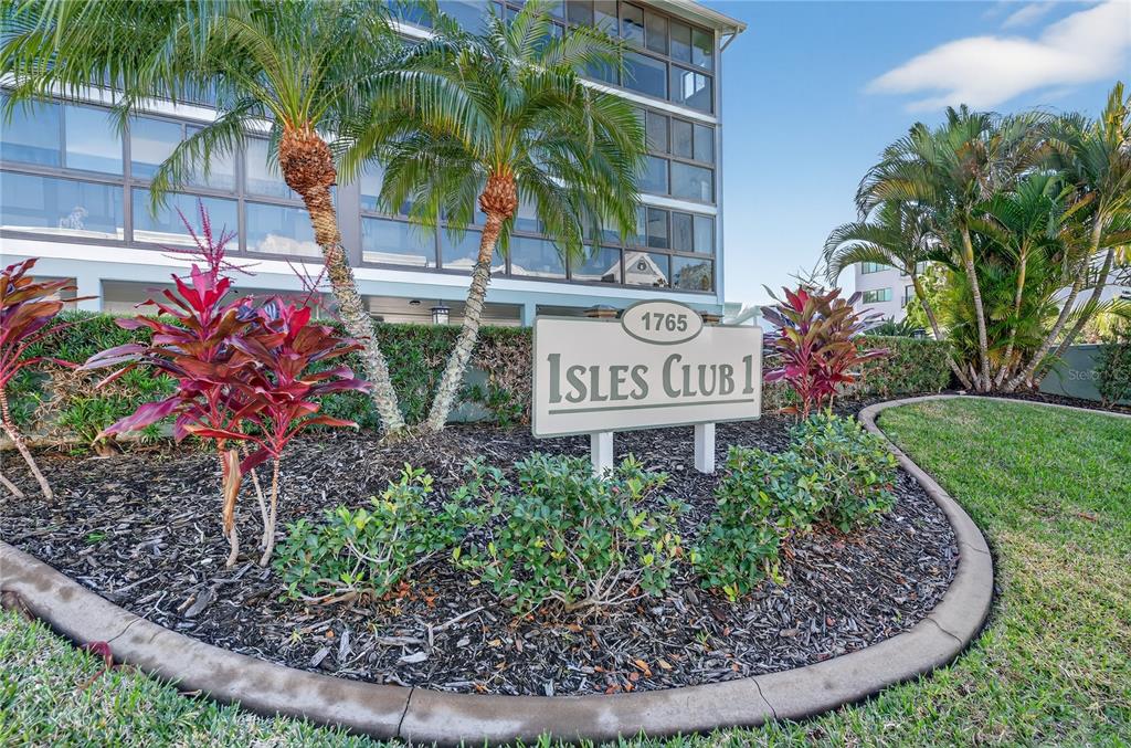 A sign for Isles Club 1 stands in front of a multi-story building with palm trees — 1765 JAMAICA WAY UNIT 101, PUNTA GORDA, FL