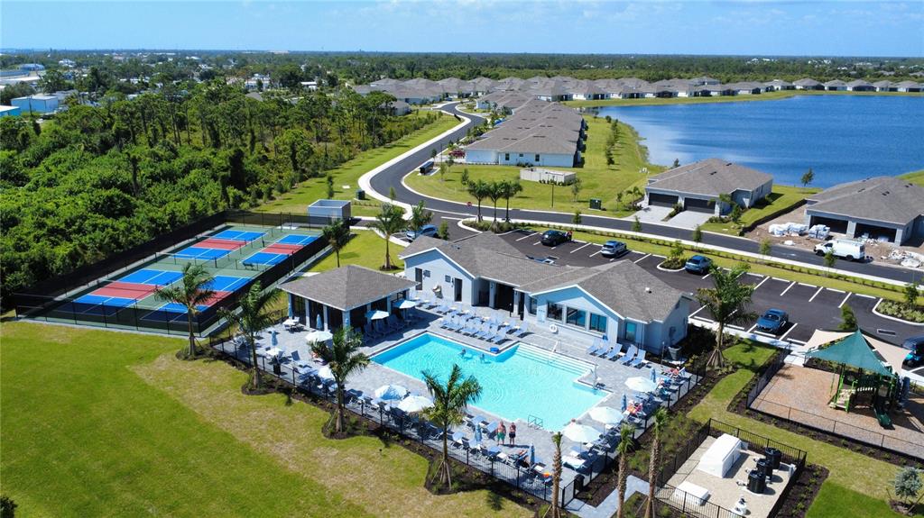 An aerial view shows a community clubhouse with a swimming pool, tennis courts, and houses — 8125 SHORE LAKE DRIVE, ENGLEWOOD, FL