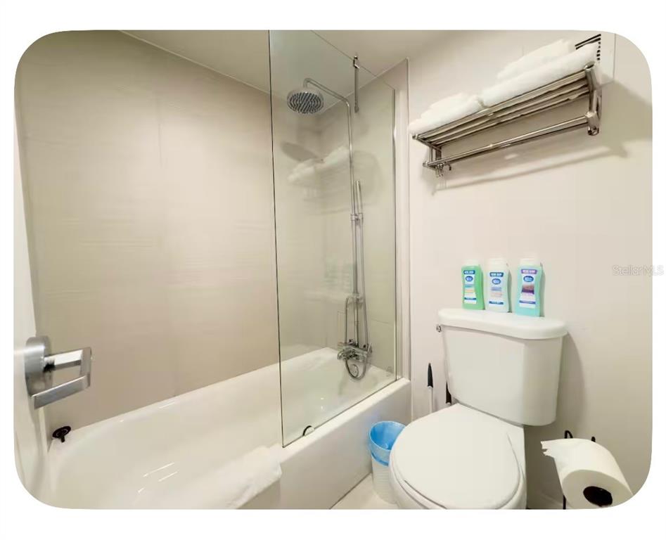 A bathroom featuring a white bathtub with a glass shower screen and a toilet — 5367 W IRLO BRONSON MEMORIAL HIGHWAY UNIT 1-205, KISSIMMEE, FL