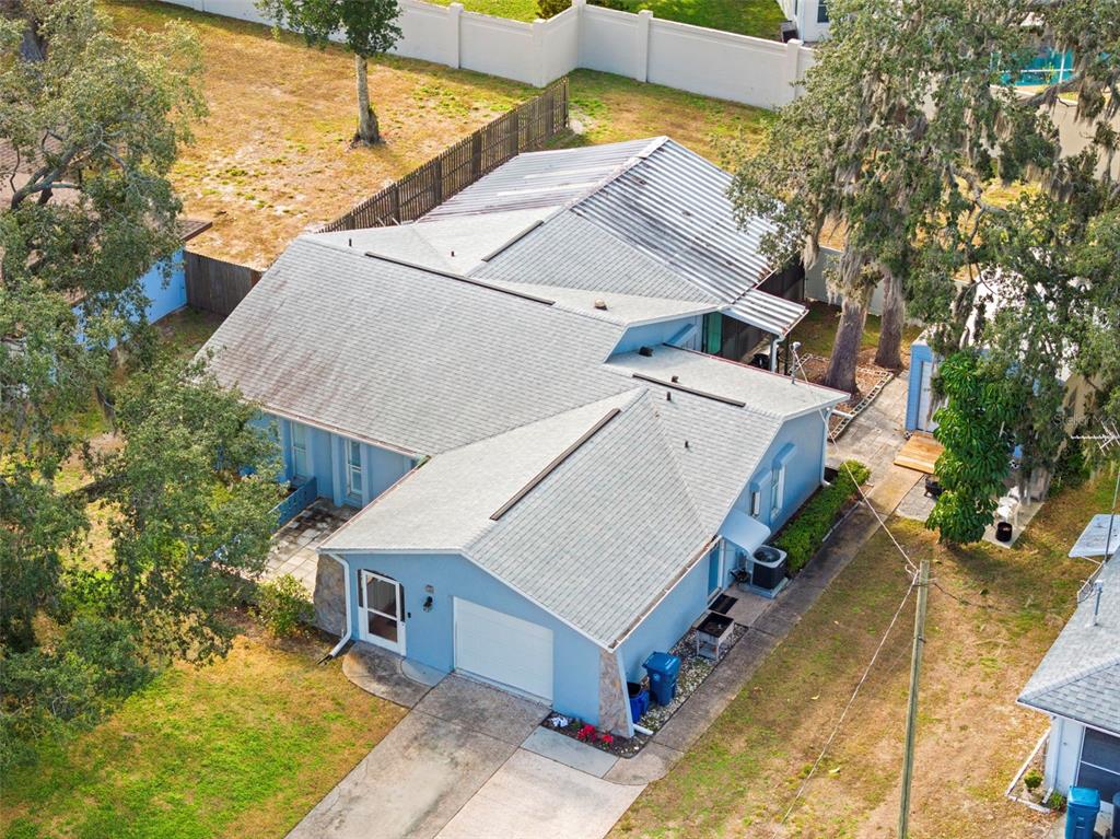 An aerial view of a light blue single-story house with a gray shingled roof — 2399 GALLAGHER AVENUE, SPRING HILL, FL