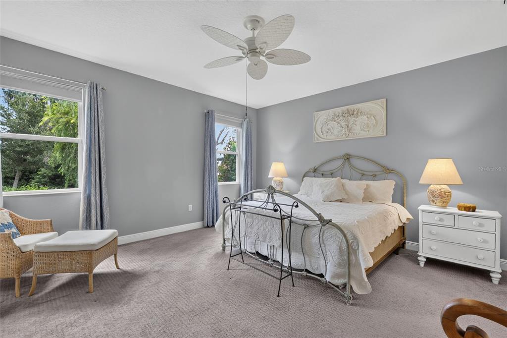 A kitchen with gray cabinets and a quartz island opens into a bright living room — 8220 BRIDGEPORT BAY CIRCLE, MOUNT DORA, FL