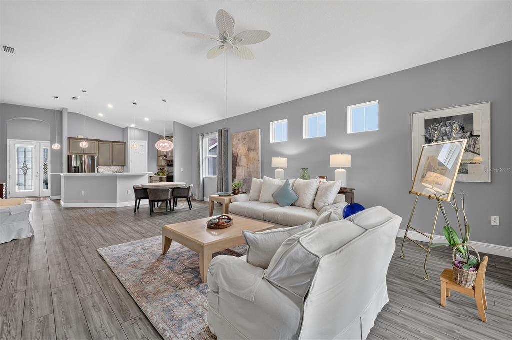 A bedroom features gray walls, a metal bed frame, a ceiling fan, and carpeted floors — 8220 BRIDGEPORT BAY CIRCLE, MOUNT DORA, FL