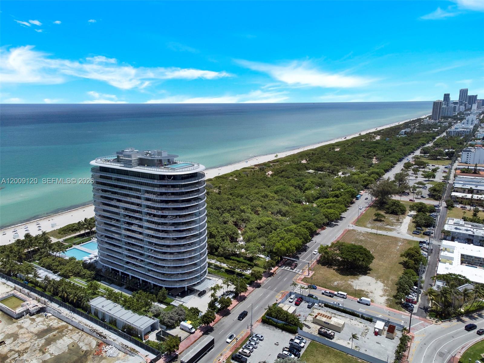 An aerial view shows a modern high-rise residential building situated next to a beach — 8701 Collins Ave # 304, Miami Beach FL 33154, MIAMI BEACH, FL