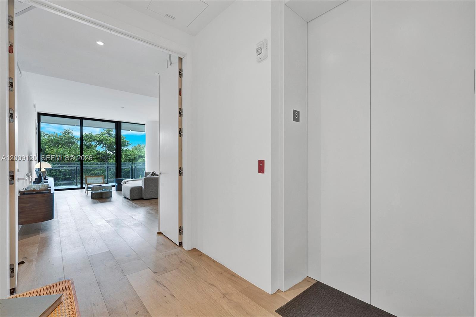 A white elevator door stands next to an open doorway leading into a living area — 8701 Collins Ave # 304, Miami Beach FL 33154, MIAMI BEACH, FL