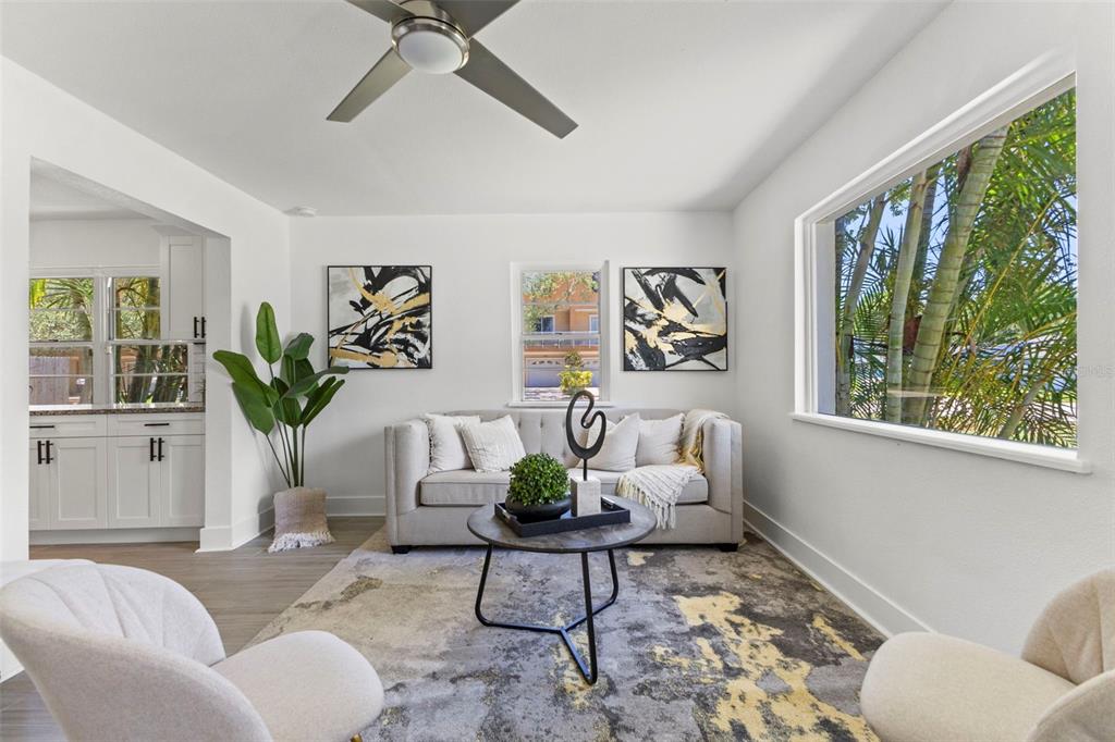 A living room features a grey sofa, two armchairs, a coffee table, and large windows — 6714 S FAUL STREET, TAMPA, FL